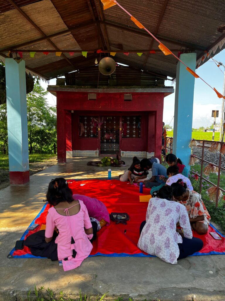 Youths are paired for the activity. The community temple becomes their temporary club space for this session