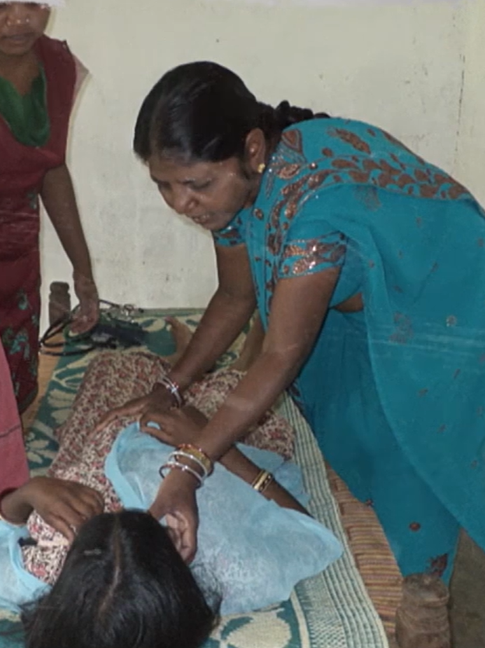 A swasthya sathi check a young girl for her health concern.