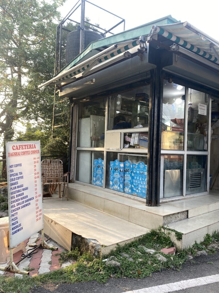 A side view of a cafeteria. On the left the menu is displayed on a standee.